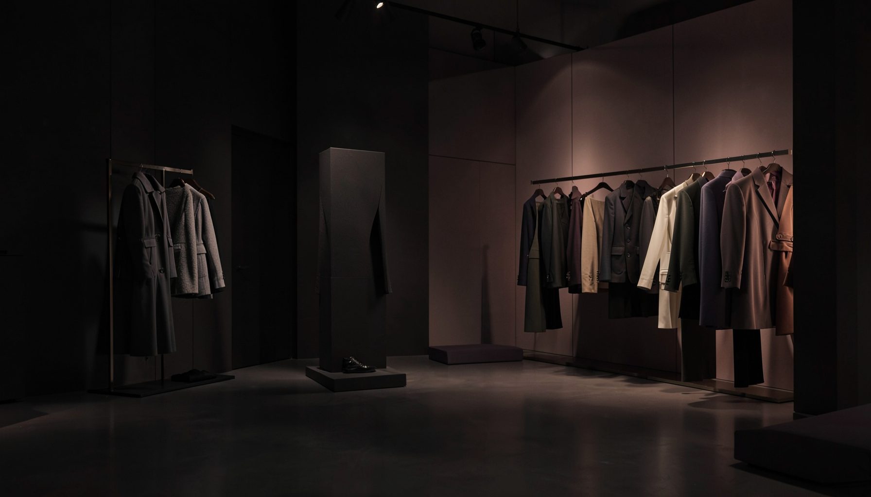 Dark atmospheric studio scene with soft warm lighting, deep charcoal and muted rose tones, sleek fashion retail mood